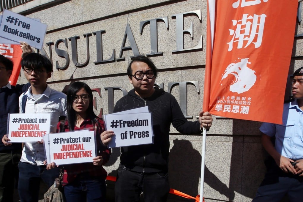 Joshua Wong (in white) with other Scholarism members protest outside the US consulate in Hong Kong over the abductions of five booksellers from the city. Picture: Sam Tsang