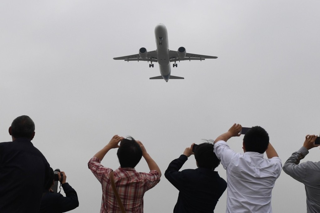 Plane spotters enjoy the spectacle of the C919’s maiden flight at Pudong International Airport in Shanghai on Friday. Photo: AFP