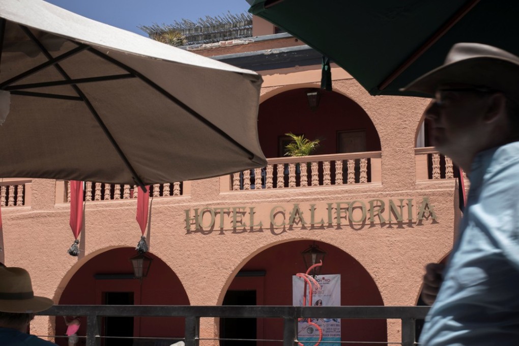 Tourists are seen in front of Hotel California in the town of Todos Santos, Baja California Sur, Mexico. The rock band Eagles has sued the owners of the hotel for capitalising on their hit song ‘Hotel California’ to popularise their hotel. Photo: Reuters
