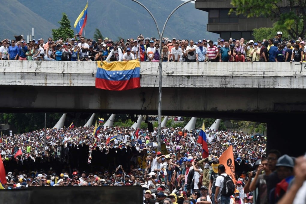 Opposition activists march during a protest against Venezuelan President Nicolas Maduro in Caracas on Wednesday. A teenage musician, Armando Canizales, was killed during one protest the same day, prompting music conductor Gustavo Dudamel to speak out. Photo: AFP
