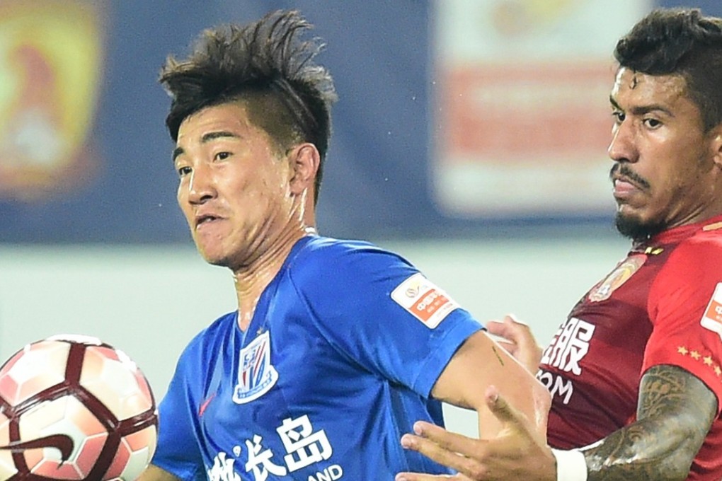 Shanghai Shenhua’s Sun Shilin (left) and Guangzhou Evergrande’s Paulinho in action. Photo: Xinhua