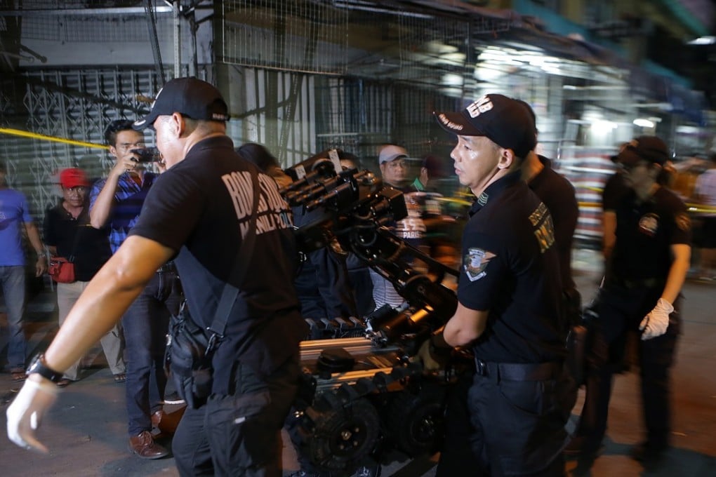 A bomb squad carries a bomb disposal robot to the scene of one of the blasts. Photo: Xinhua