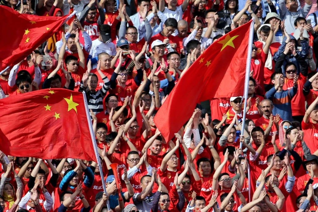 China's fans cheer during the 2018 World Cup qualifying football match between Iran and China at the Azadi Stadium in Tehran on March 28, 2017. / AFP PHOTO / ATTA KENARE