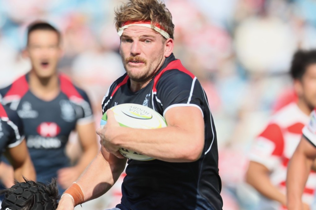 James Cunningham takes on the tackler in Hong Kong’s loss to Japan. Photo: Kenji Demura, Rugby Japan