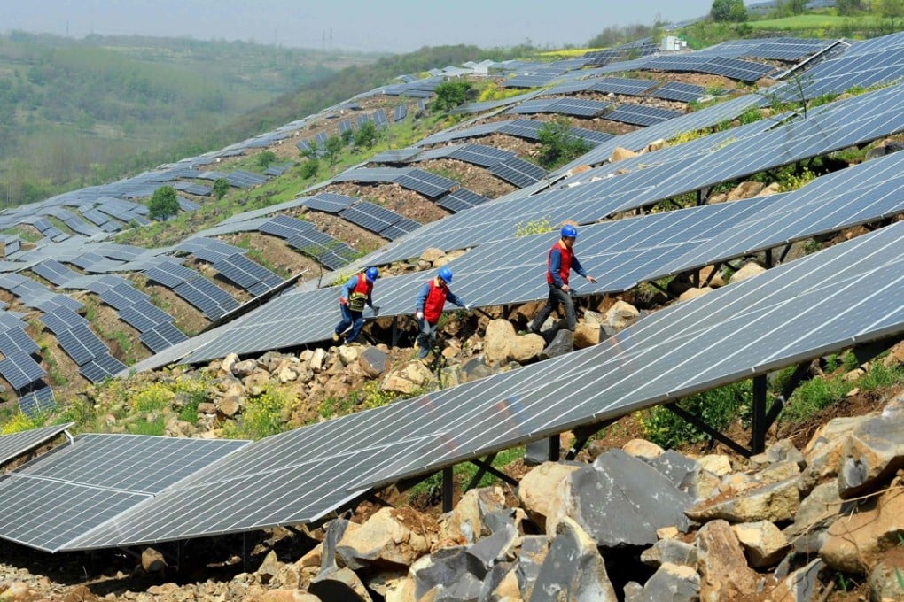 Chinese workers check solar panels last month on a hillside in a village in Chuzhou, Anhui province. China is now home to the world’s fastest-growing renewable energy industry. Photo: AFP
