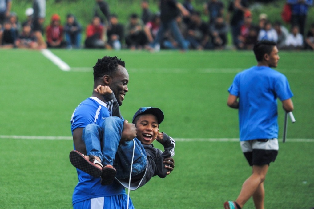 Former Chelsea player Michael Essien holds a supporter of his new club Persib in Bandung, Indonesia. Photo: Reuters
