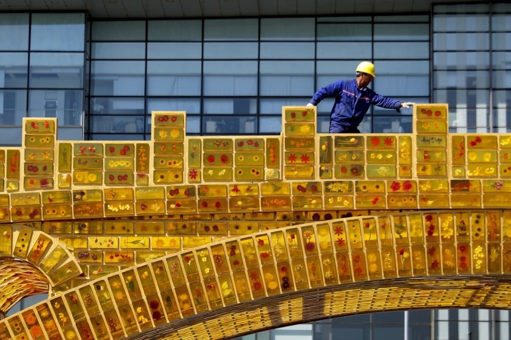 A worker walks on a 'Golden Bridge of Silk Road' structure on display outside the National Convention Centre, the venue for the Belt and Road Forum for International Cooperation, in Beijing. Photo: AP