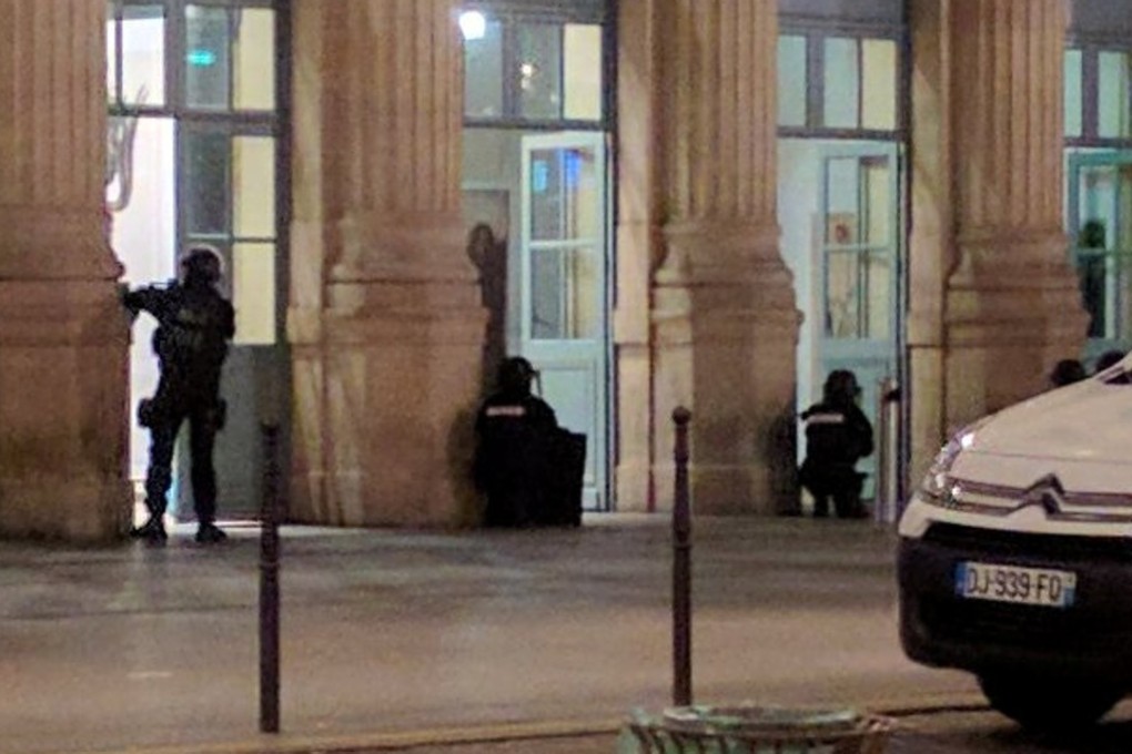 Police officers with guns drawn crouch at an entrance of the Paris' Gare du Nord train station, Paris, on Monday. Photo: Reuters