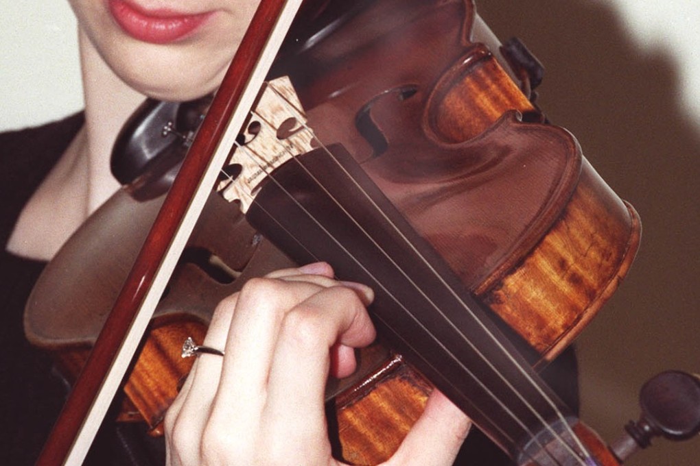 A Sotheby's employee, Charlotte Bassett, plays a 1682 Stradivarius violin in the auction house in central London in 2001. Photo: AP