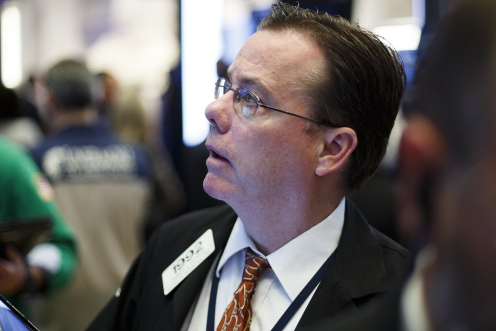 Traders work on the floor of the New York Stock Exchange as the tech-heavy Nasdaq index notched another record and should give Asian stocks a boost on Wednesday. Photo: EPA