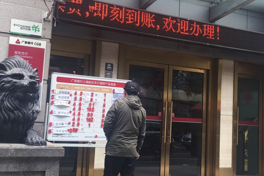 A passerby looks at the advertisement of an Anbang Insurance Group's universal insurance policy and other wealth management products available at a China Guangfa Bank outlet in Shanghai. Photo: Maggie Zhang