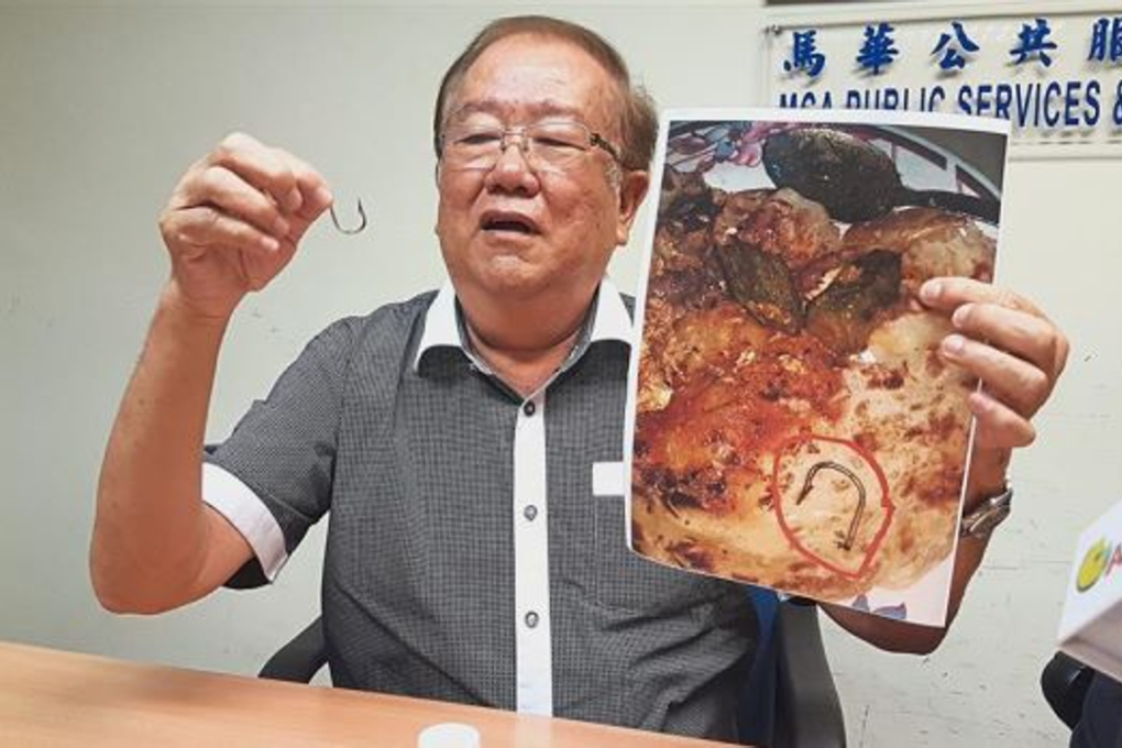 Chong holding up the fish hook he found in the fish head curry from a restaurant in Petaling Jaya. Photo: The Star