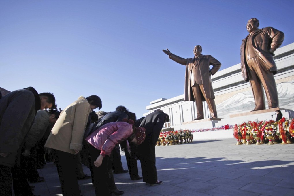 North Koreans bow to bronze statues of the late leaders, Kim Il-sung, left, and his son Kim Jong-il, on Mansu Hill in Pyongyang, North Korea. Photo: AP
