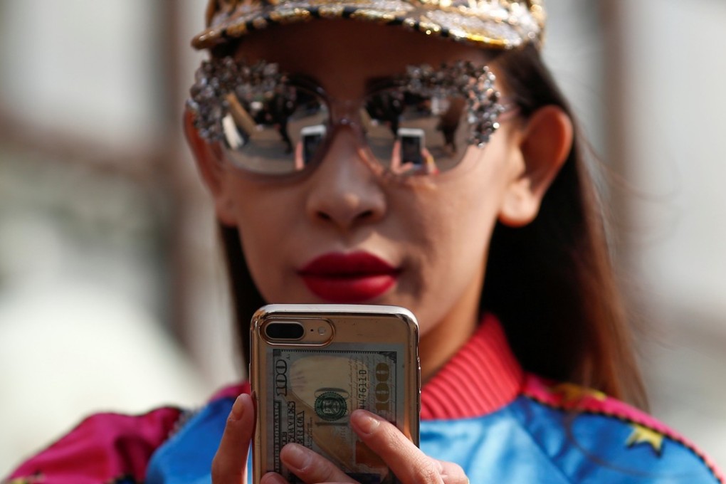 A woman uses a mobile phone during China Fashion Week in Beijing. Photo: Reuters