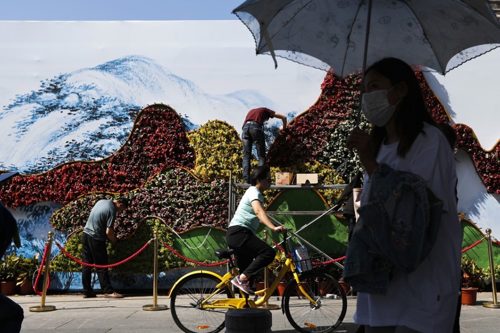 Workers plant flowers near the Xidan Cultural Square ahead of the Belt and Road Forum in Beijing. Photo: AP