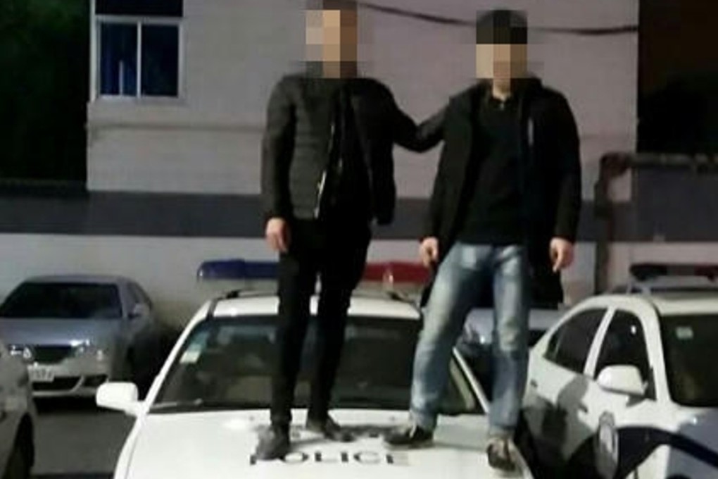 Self-incriminating evidence. Two of the thieves stood on the bonnet of a police car and posted the photos online. Photo: Handout