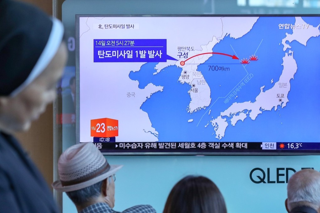 Passengers watch a news report on North Korea’s missile test at a railway station in Seoul on Sunday. Photo: Reuters