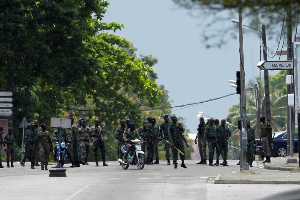 Mutinous soldiers stand next to their camp as they protest in a pay dispute in the centre of the Ivory Coast commercial capital Abidjan on Friday. Photo: Reuters