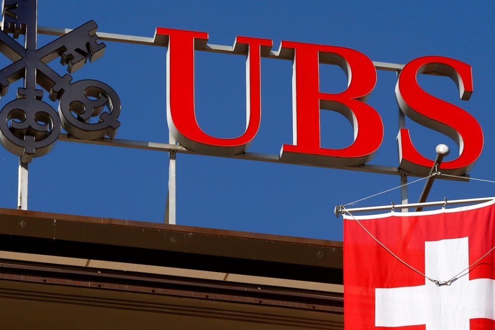 Switzerland's national flag flies under the logo of Swiss bank UBS in Zurich, Switzerland. Singapore GIC Private Ltd is selling part of its stake in the bank. Photo: Reuters