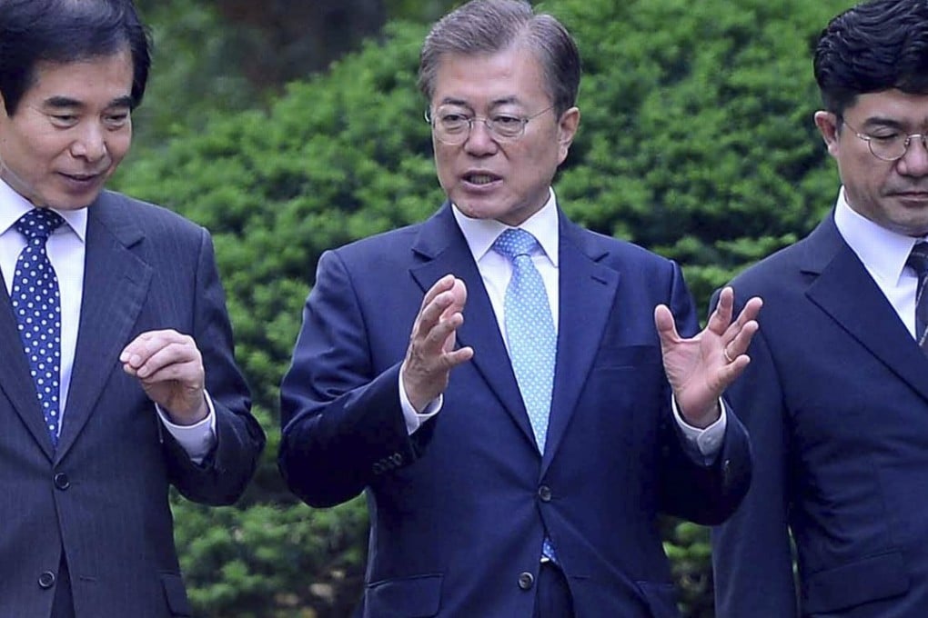South Korean President Moon Jae-in speaks to his aides while walking to his office building at the Blue House presidential compound in Seoul. Photo: EPA