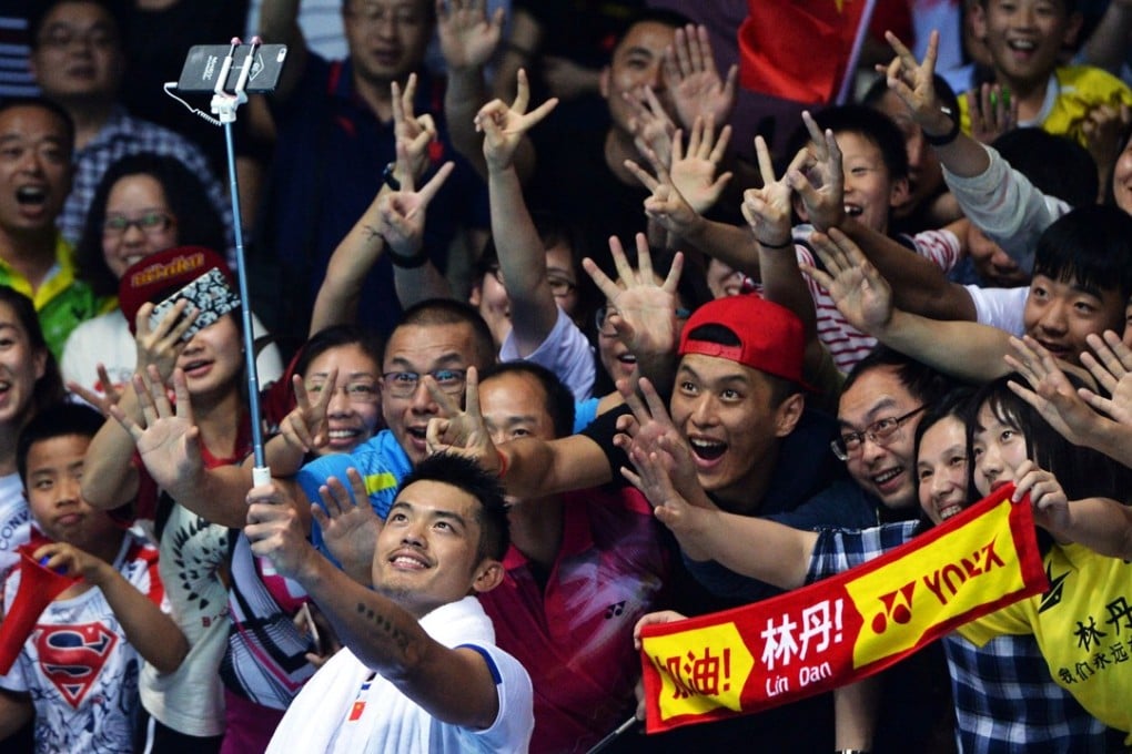 China's Lin Dan poses with fans after losing the men's singles final against compatriot Chen Long at the 2017 Badminton Asia Championships in Wuhan, in central China's Hubei province on April 30, 2017. / AFP PHOTO / STR / CHINA OUT