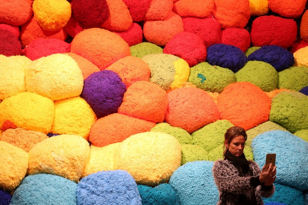 A visitor takes a selfie in front of Escalade Beyond Chromatic Lands, an installation by American artist Sheila Hicks, during the 57th Venice Biennale. Photo: Reuters