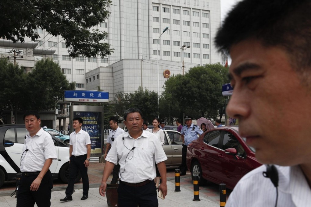 Plain-clothes personnel pursue onlookers outside the Tianjin No 2 Intermediate People's Court, site of the trial of human rights lawyer Zhou Shifeng in August. Photo: EPA