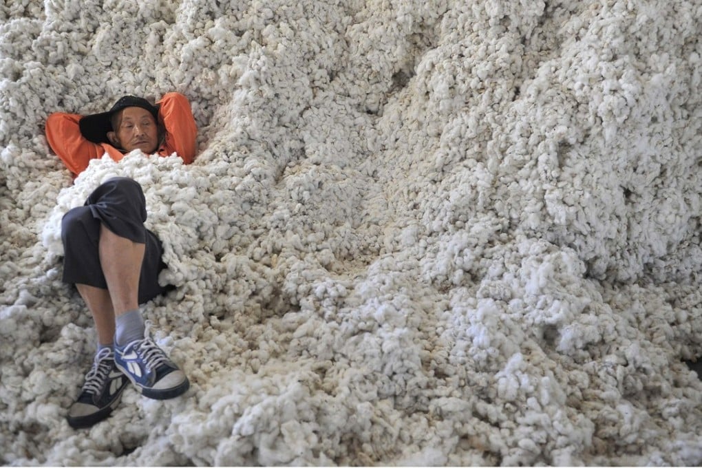 A worker rests on piles of cotton at a ginning factory in Wuhu, Anhui province. Photo: Reuters