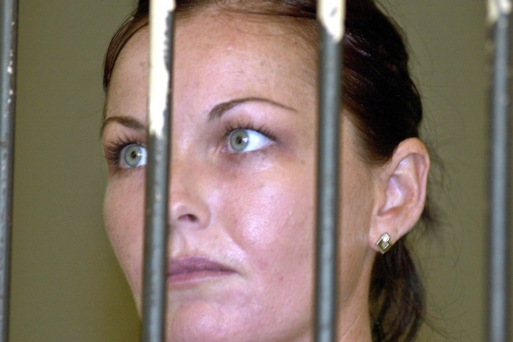 Convicted drug smuggler Schapelle Corby stands behind the bars at court's prison. Photo: AP