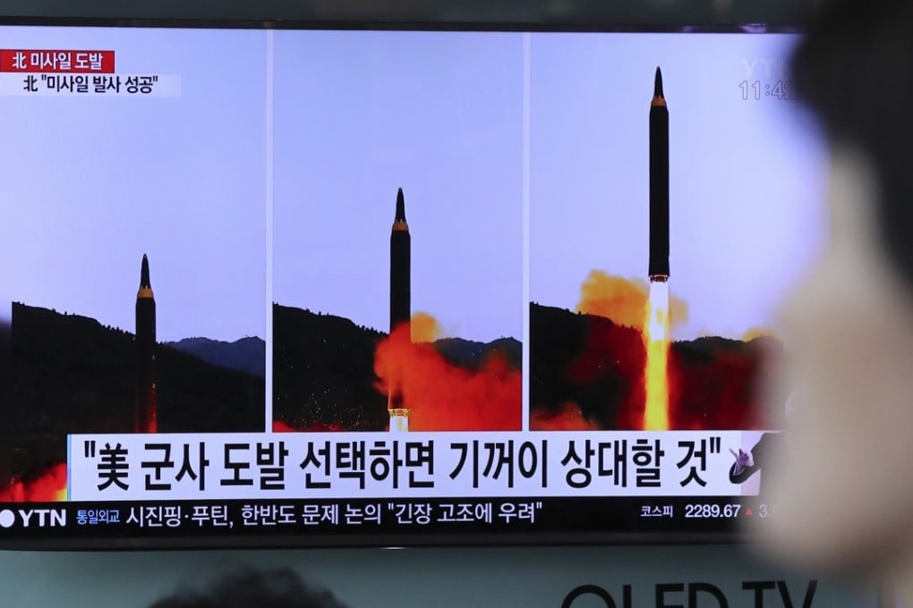 A woman walks by a TV news programme showing images of North Korean missile launch on May 15. Photo: AP