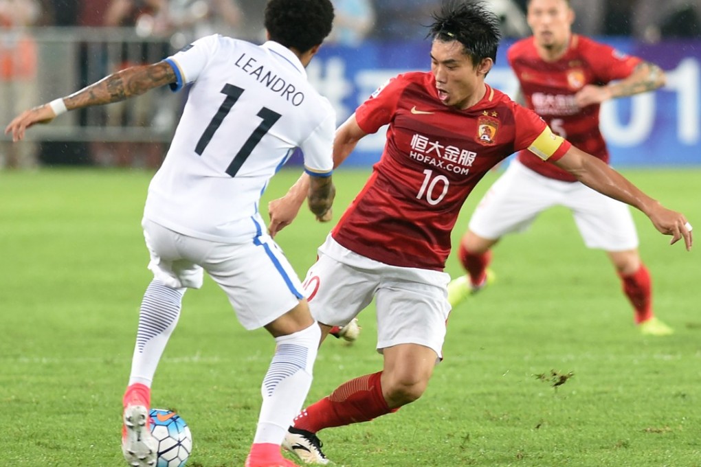 Guangzhou Evergrande’s Zheng Zhi (10) goes in for the tackle against Kashima Antlers’ Leandro. Photo: Xinhua