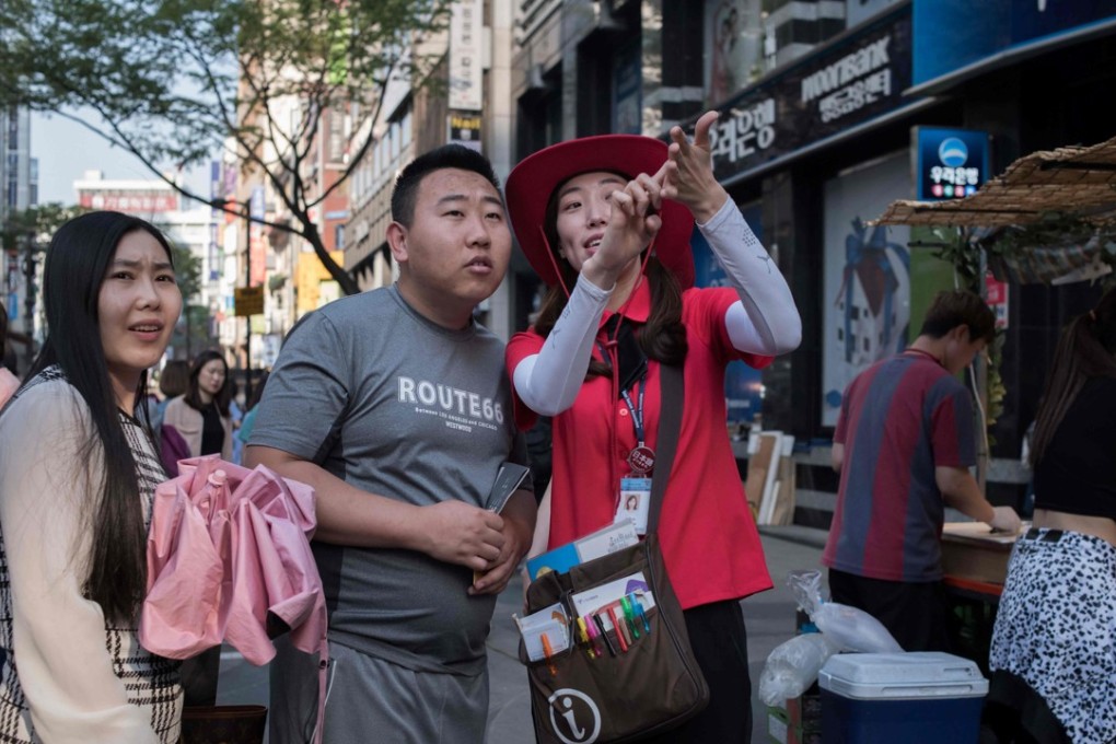 A South Korean guide directing tourists in the popular Myeongdong shopping area of Seoul. Photo: AFP