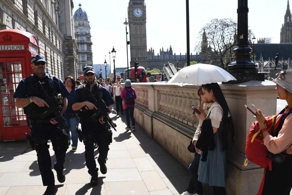 Armed police patrol a street near the Palace of Westminster. Photo: AFP