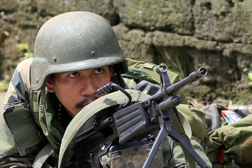 A government soldier positions himself during an assault with insurgents. Photo: Reuters