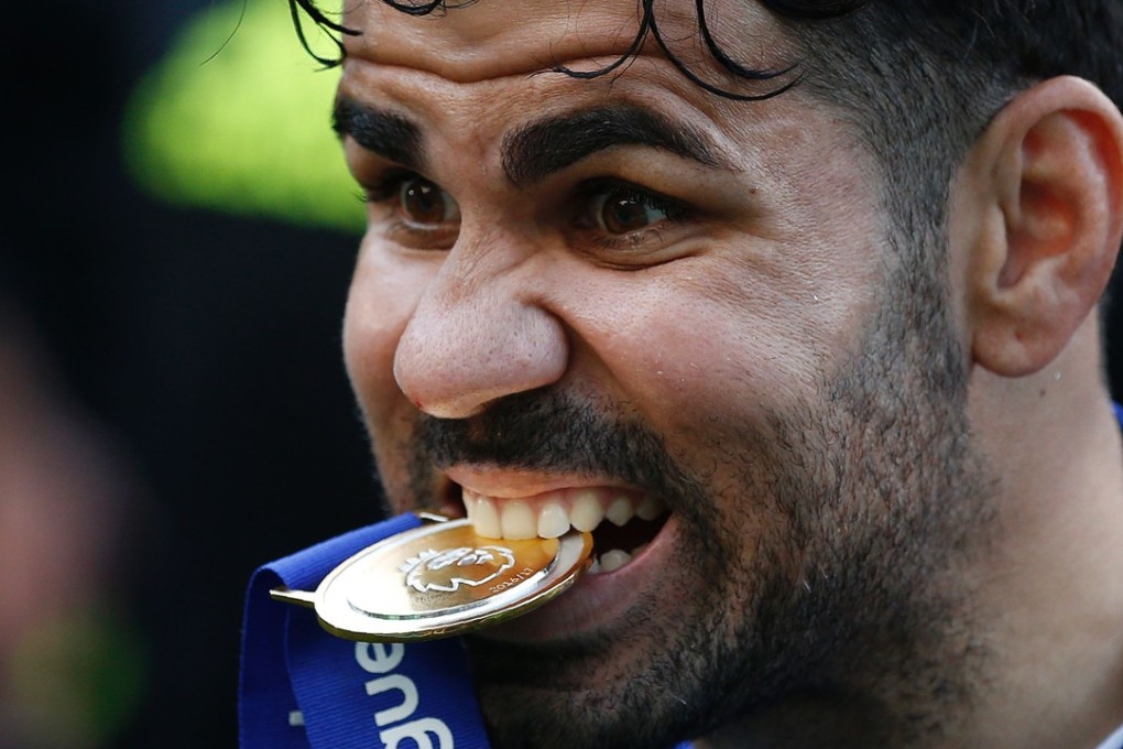 Chelsea's Brazilian-born Spanish striker Diego Costa poses with his winner's medal, as players celebrate their league title win at the end of the Premier League football match between Chelsea and Sunderland at Stamford Bridge in London on May 21, 2017. Chelsea's extended victory parade reached a climax with the trophy presentation on May 21, 2017 after being crowned Premier League champions with two games to go. / AFP PHOTO / Ian KINGTON / RESTRICTED TO EDITORIAL USE. No use with unauthorized audio, video, data, fixture lists, club/league logos or 'live' services. Online in-match use limited to 75 images, no video emulation. No use in betting, games or single club/league/player publications. /