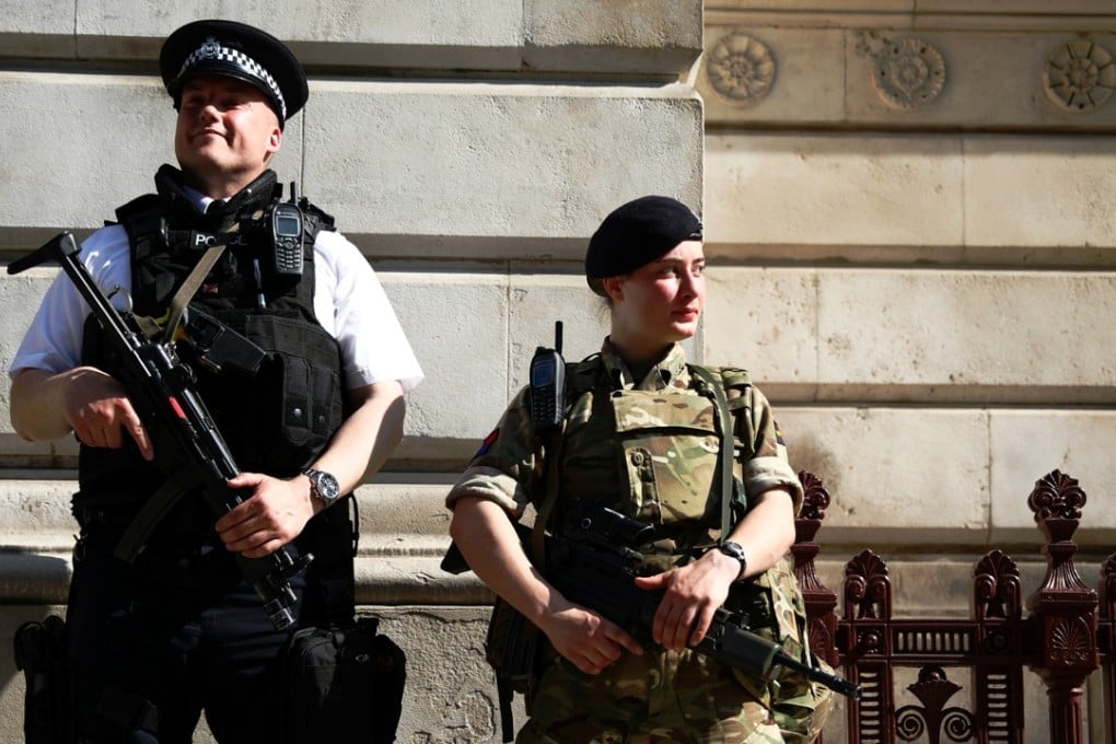 A soldier and a police officer stand guard at Downing Street in London. Photo: Reuters