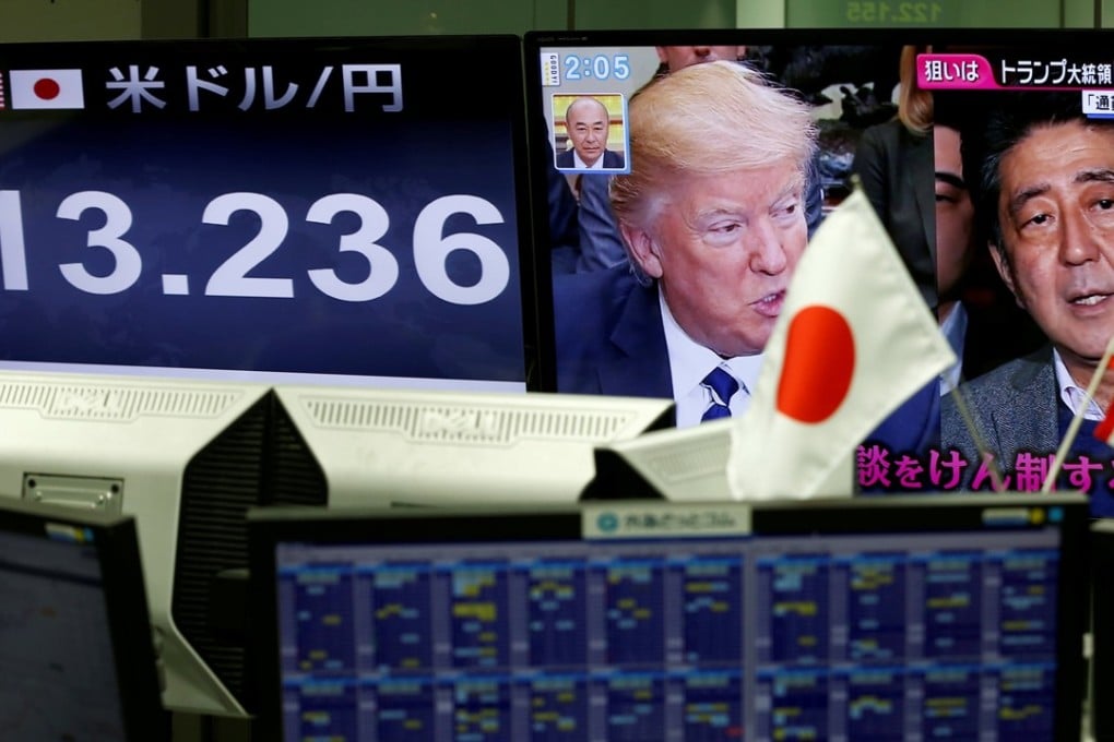 US President Donald Trump and Japanese Prime Minister Shinzo Abe seen on a TV monitor as the one next to it shows the yen’s exchange rate against the US dollar, at a forex trading company in Tokyo on February 1. Photo: Reuters