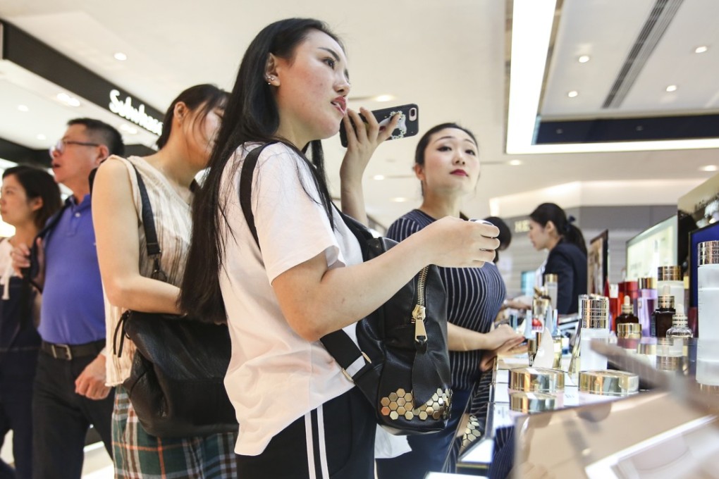 Young shoppers test beauty products at the Estee Lauder counter in Sogo in Causeway Bay. Photo: Edward Wong