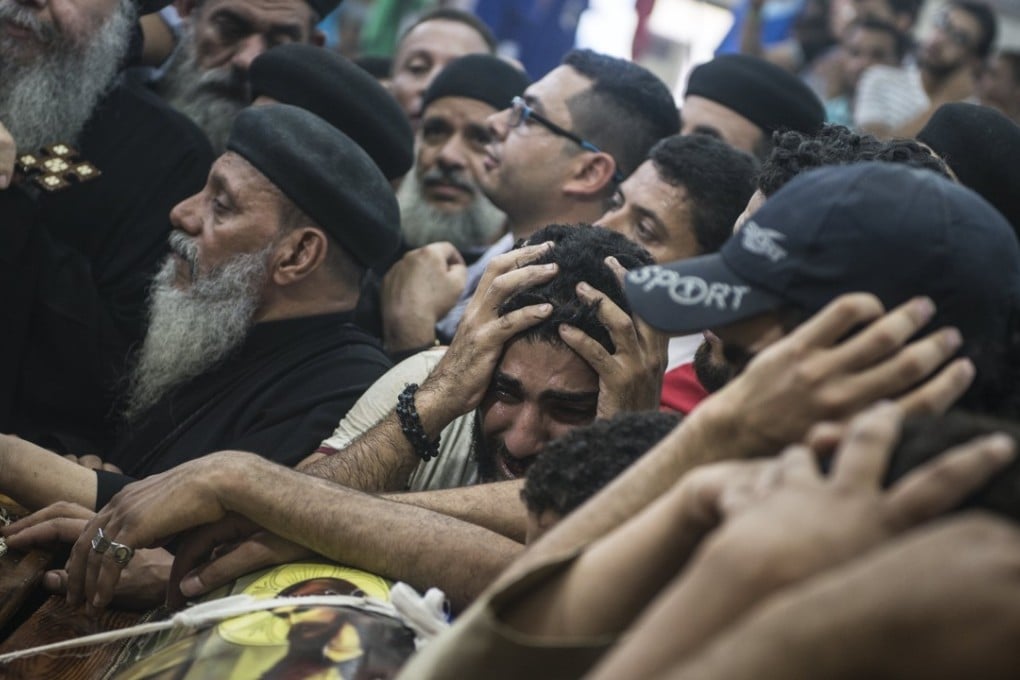 Relatives mourn over coffins of victims during the funeral of people killed in Minya. Photo: EPA