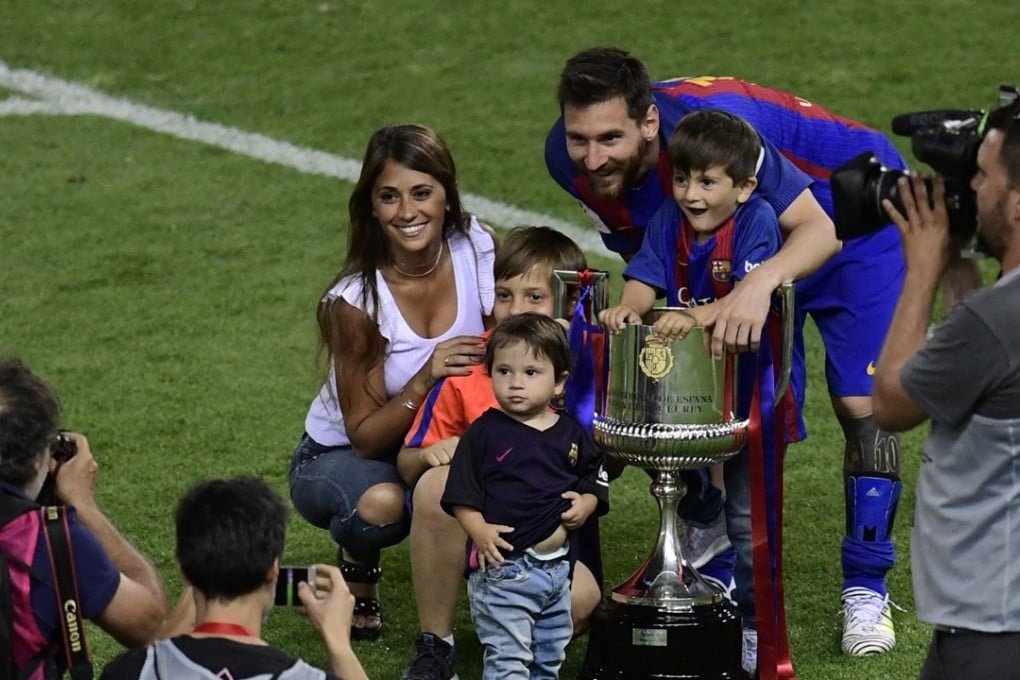 Barcelona's Argentinian forward Lionel Messi (C), his wife Antonella Roccuzzo and sons pose with the trophy at the end of the Spanish Copa del Rey (King's Cup) final football match FC Barcelona vs Deportivo Alaves at the Vicente Calderon stadium in Madrid on May 27, 2017. Barcelona won 3-1. / AFP PHOTO / JAVIER SORIANO