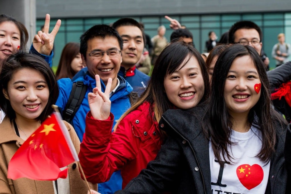 Chinese students show support for Chinese President Xi Jinping as he arrives to tour the National Graphene Institute at Manchester University in English in October 2015. Photo: AFP