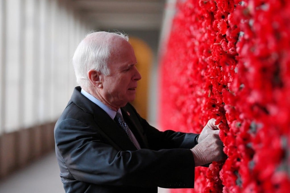 United States Senator John McCain places a poppy on the Roll of Honour wall during a visit to the Australian War Memorial in Canberra, Australia, on Monday. Photo: Reuters