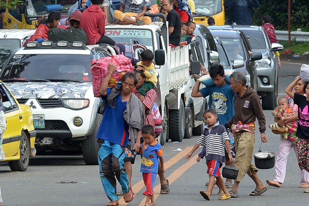 Families carrying their belongings flee Marawi city, in the southern mainly Muslim island of Mindanao, on May 26, amid fighting between Islamist militants and government forces. Photo: AFP