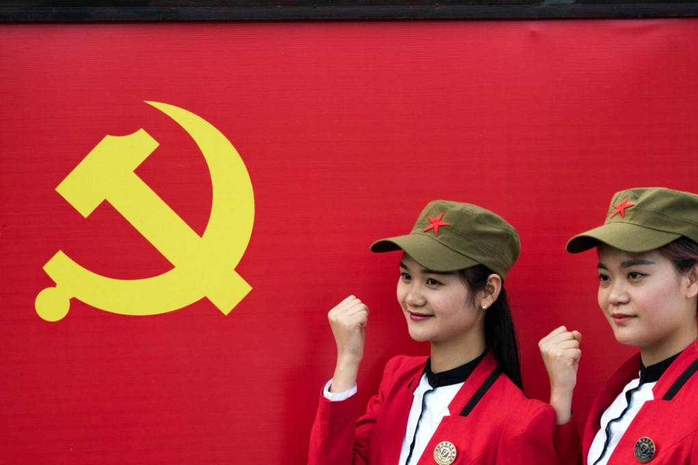 Chinese tourists posing in front a flag of the Communist Party of China in Shaoshan in Hunan province. Shaoshan is the hometown of Mao Zedong. The small village is a hot spot for 'red tourism'. Millions of Mao devotees from all over the country come to Shaoshan every year. Photo: AFP