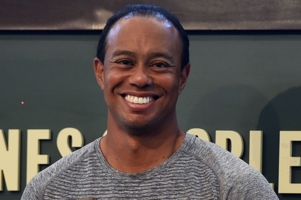 This file photo taken on March 20, 2017 shows 14-time major champion golfer Tiger Woods holding a copy of his new book ''The 1997 Masters: My Story " before his book signing at Barnes & Noble's Union Square in New York. His arrest for DUI in Florida may impact those who sponsor the golfer. Photo: AFP