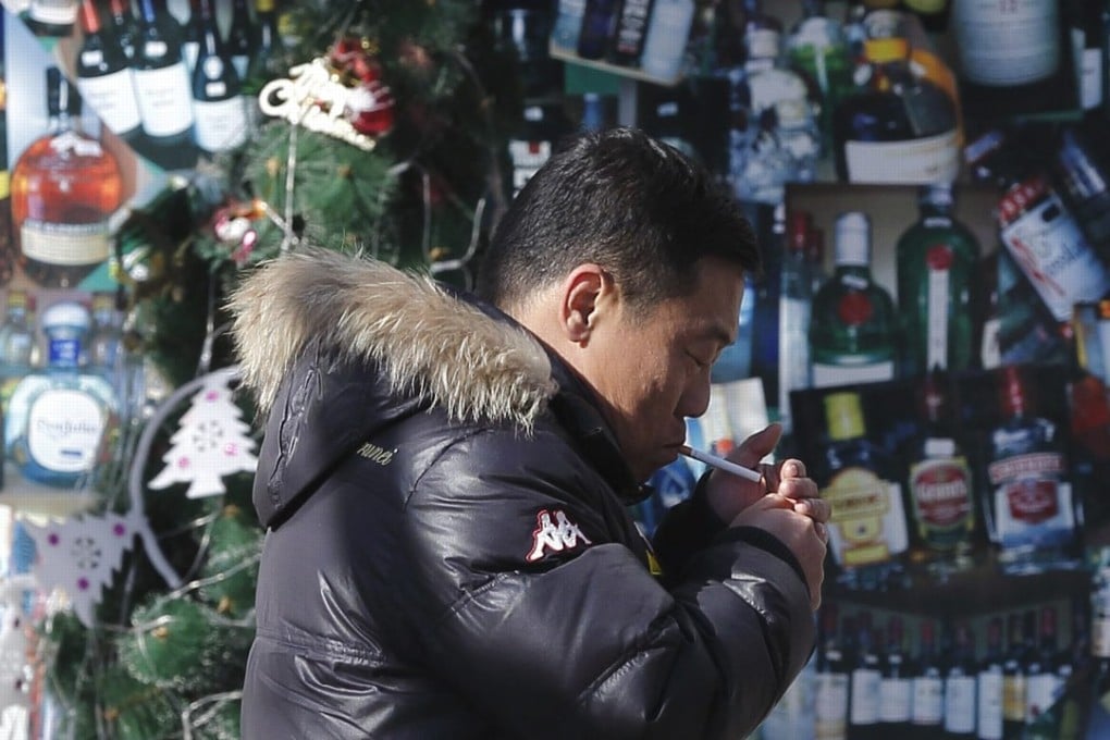 A file picture of a man lighting up outside a convenience store in Beijing. Photo: EPA