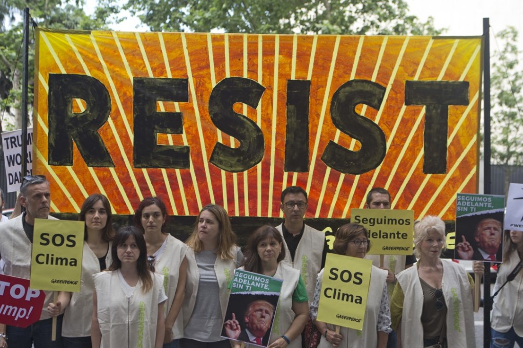 Greenpeace protesters stand in silence with banners outside the US embassy in Madrid, Spain, in protest against President Donald Trump’s decision to pull the world's second-largest carbon dioxide emitter out of the Paris Agreement. Photo: AP