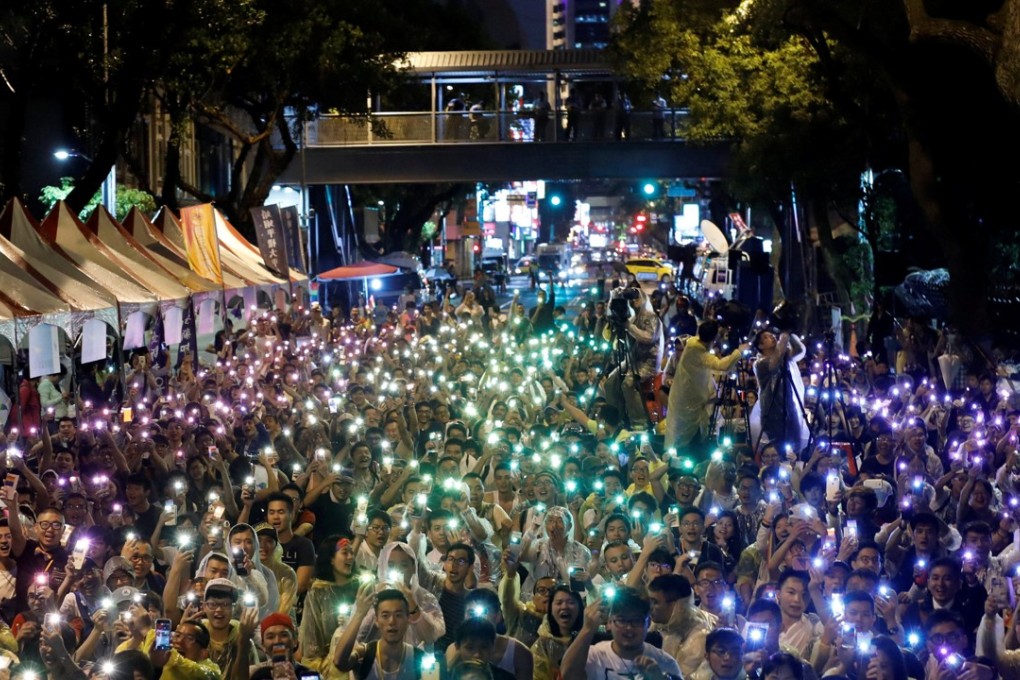 Supporters wave their mobile phone torches in the colours of the rainbow during a rally in Taipei after Taiwan's constitutional court ruled that same-sex couples have the right to legally marry. Photo: Reuters