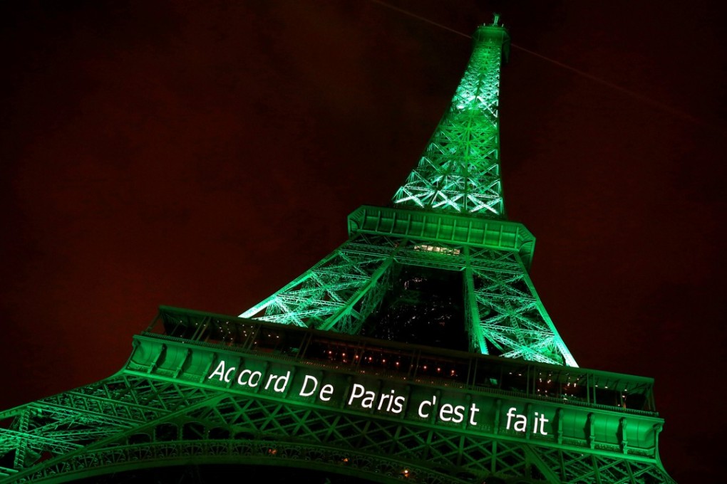 The Eiffel tower is illuminated in green with the words ‘Paris agreement is done’. Photo: Reuters