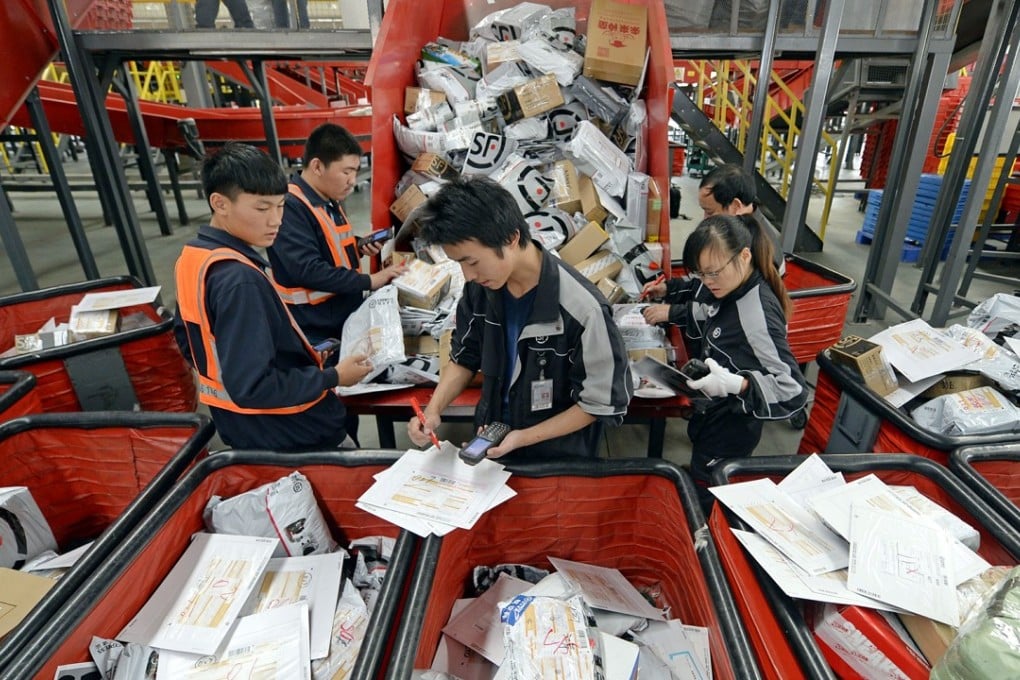 Workers sort out parcels at a distribution centre of SF Express in Wuhan. Photo: Imaginechina